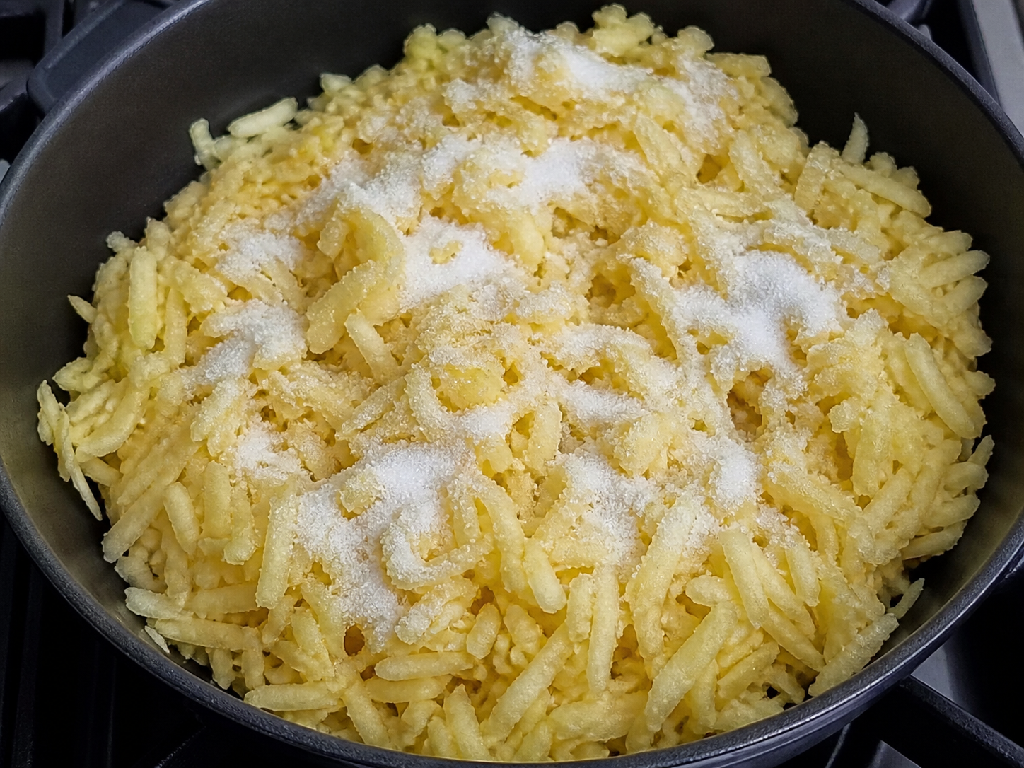 Grated apples cooking with sugar for the pie filling