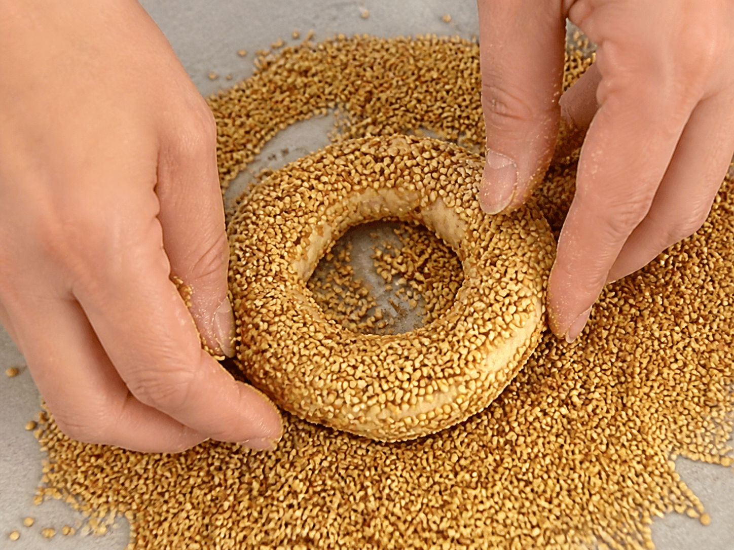 Savory cookie dough shaped into a ring and coated with sesame seeds
